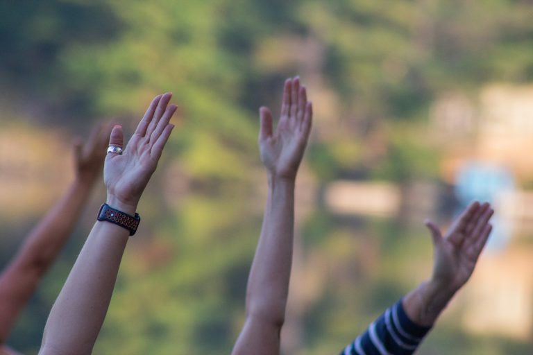 A photo of a group of people raising hands