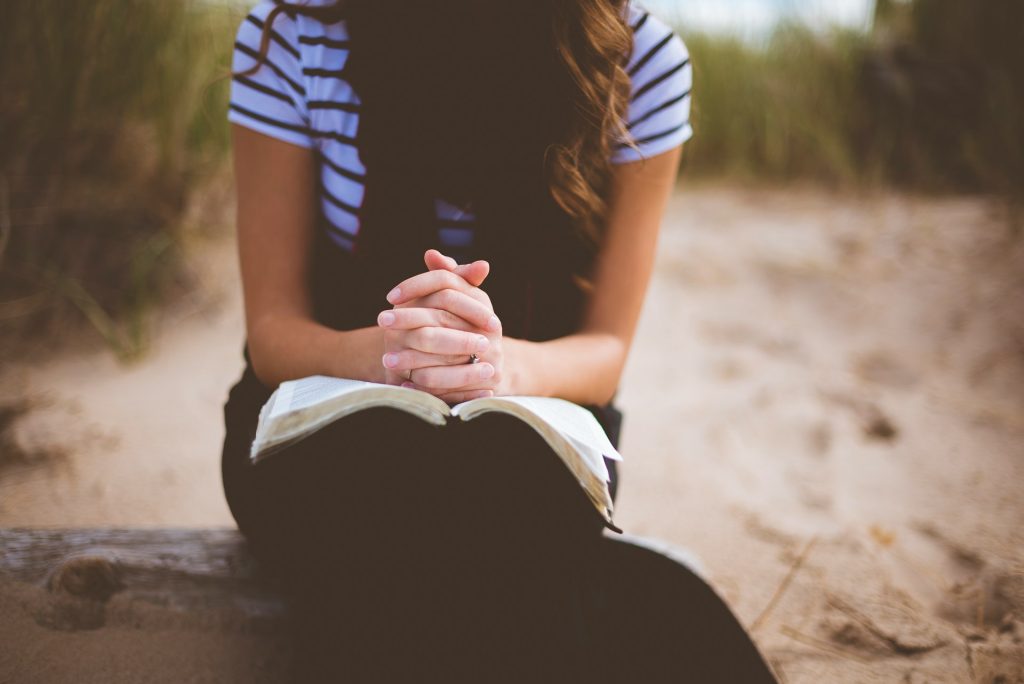 Person holding an open Bible while learning how to pray when they don’t know what to say