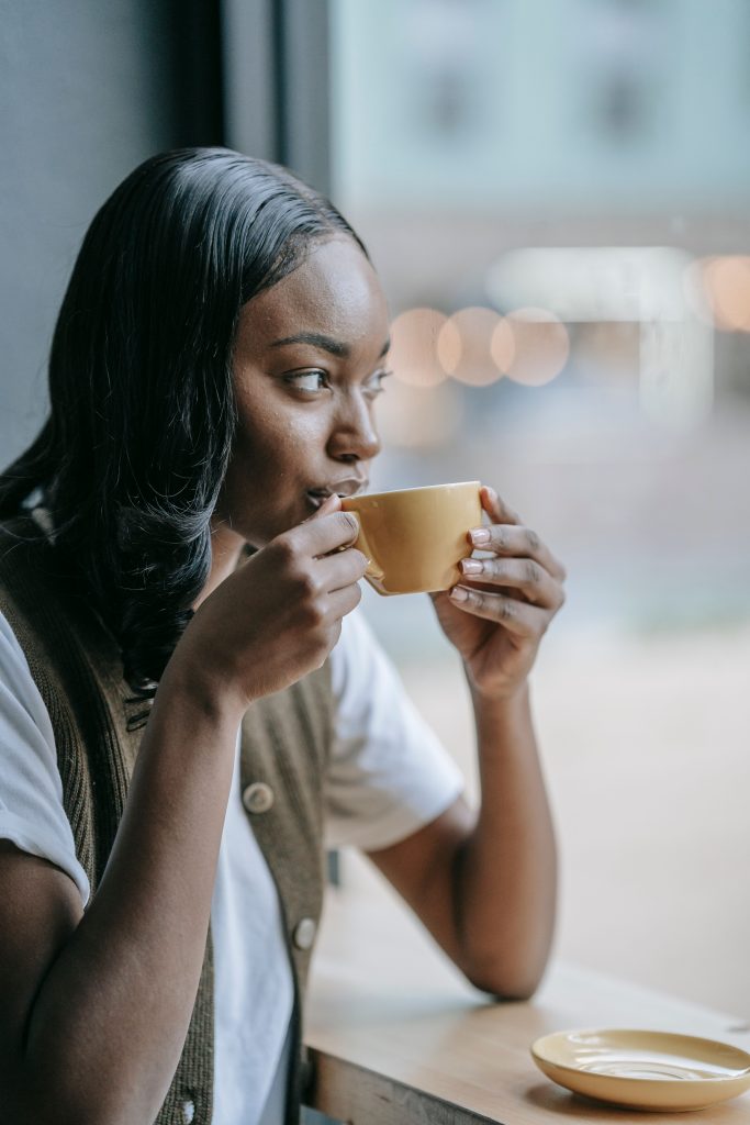 Woman pausing over a cup of coffee — Bible verses for loneliness