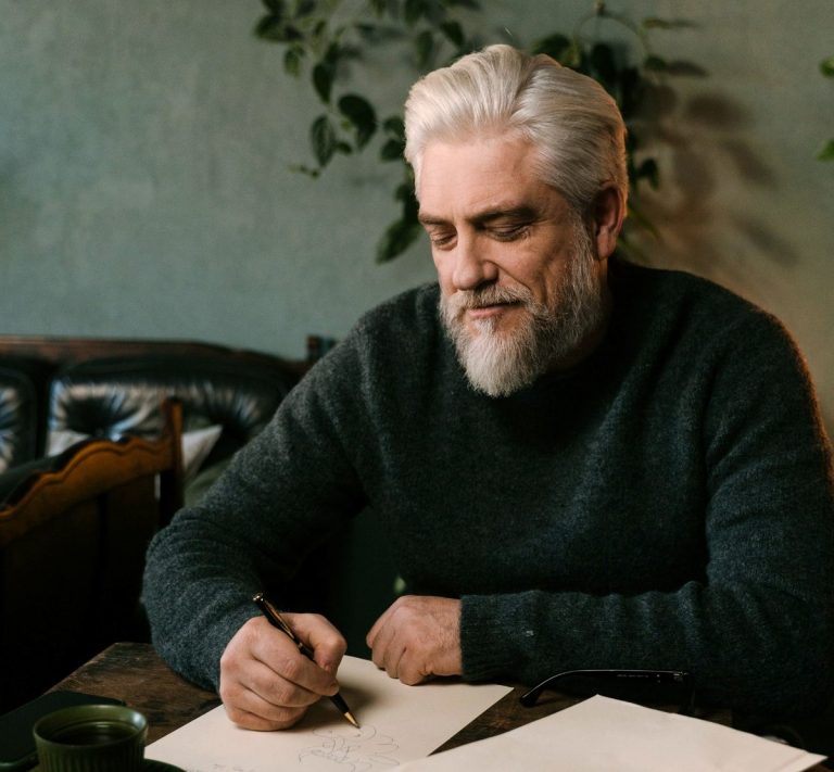 A mature man writing at a table — finding purpose in later life