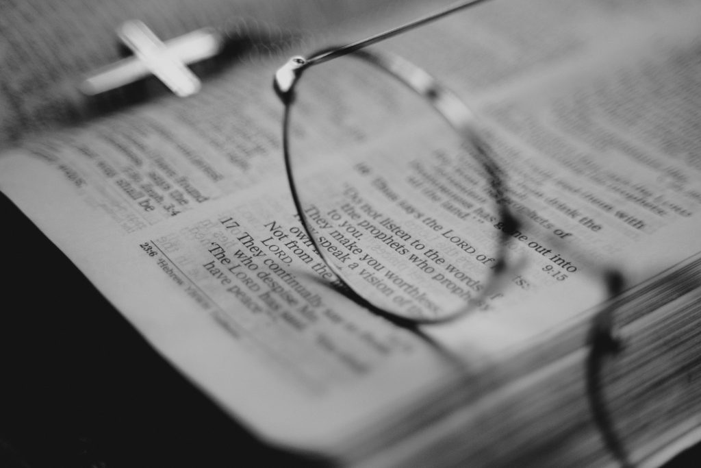 Reading glasses resting on an open Bible — wise as serpents and harmless as doves