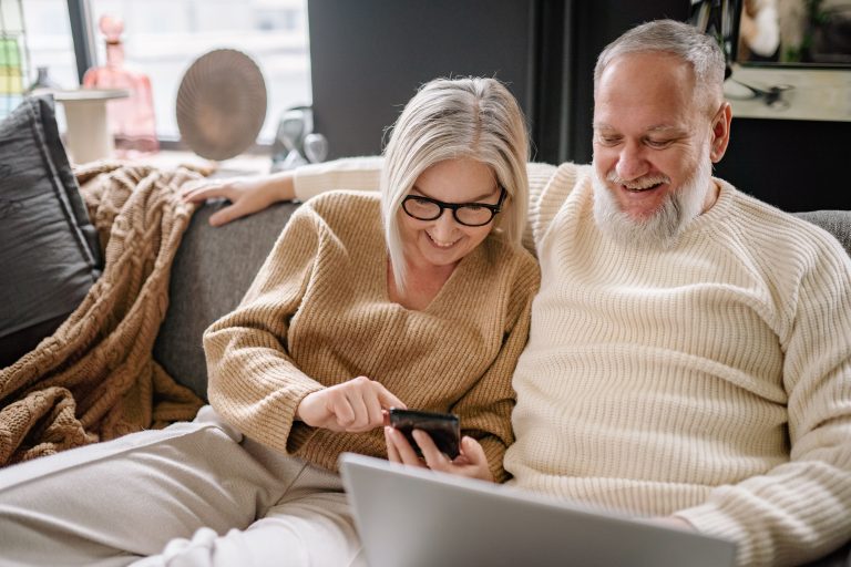 Mature couple looking at a phone together on the couch — should Christians use AI